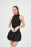 Sleek black mini dress with ruffle trim and turtleneck, showcasing modern fashion.