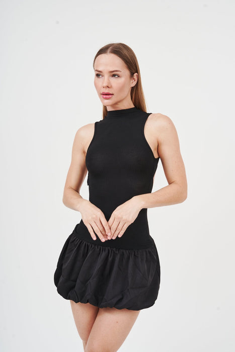 Sleek black mini dress with ruffle trim and turtleneck, showcasing modern fashion.