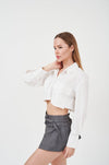 Stylish ruffle-trim white blouse with flared sleeves, modeled in studio setting.