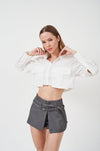 Stylish cropped blouse with ruffled sleeves and flared cuffs against a plain background.