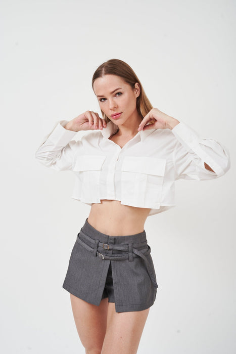 Stylish cropped blouse with ruffled sleeves and flared cuffs against a plain background.