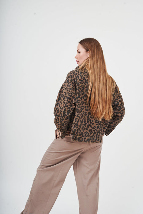 Chic leopard print denim jacket for effortless style, model with long flowing hair wearing the jacket against a plain white background.