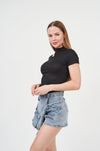 Stylish Denim Shorts with Distressed Accents - Fashionable woman posing in denim shorts and black top from H Apparel's latest collection.