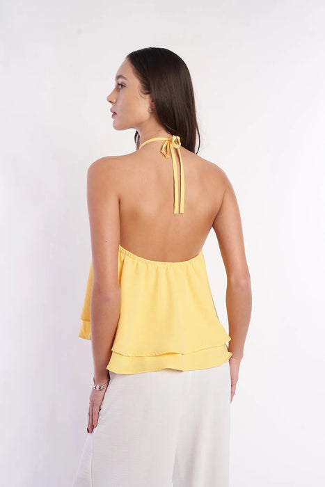 Elegant floral embroidered yellow halter top showing woman's back