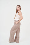 Elegant satin top and wide-leg trousers set on woman in studio.