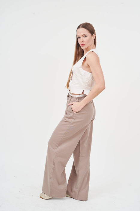 Elegant satin top and wide-leg trousers set on woman in studio.