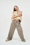 Wide-leg linen blend trousers with a tie waist, showcased on a model in a yellow top against a plain background.